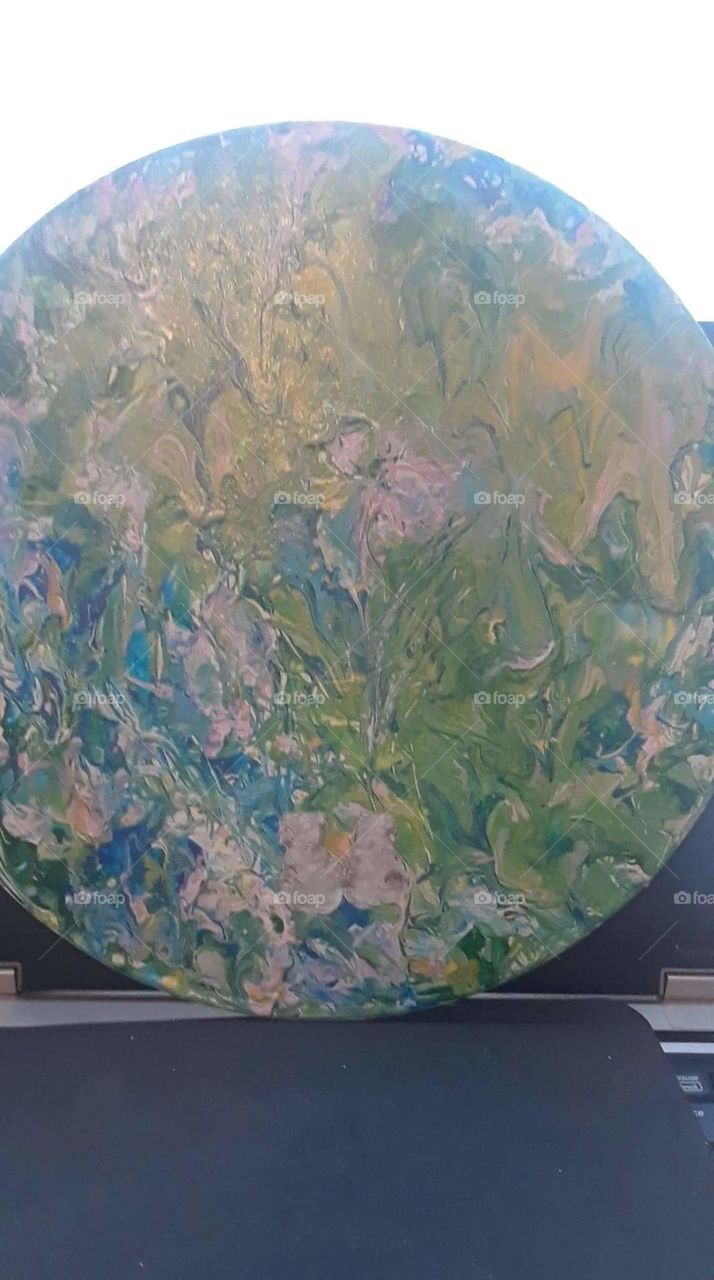 Acrylic painting with a springtime scene on a round surface.