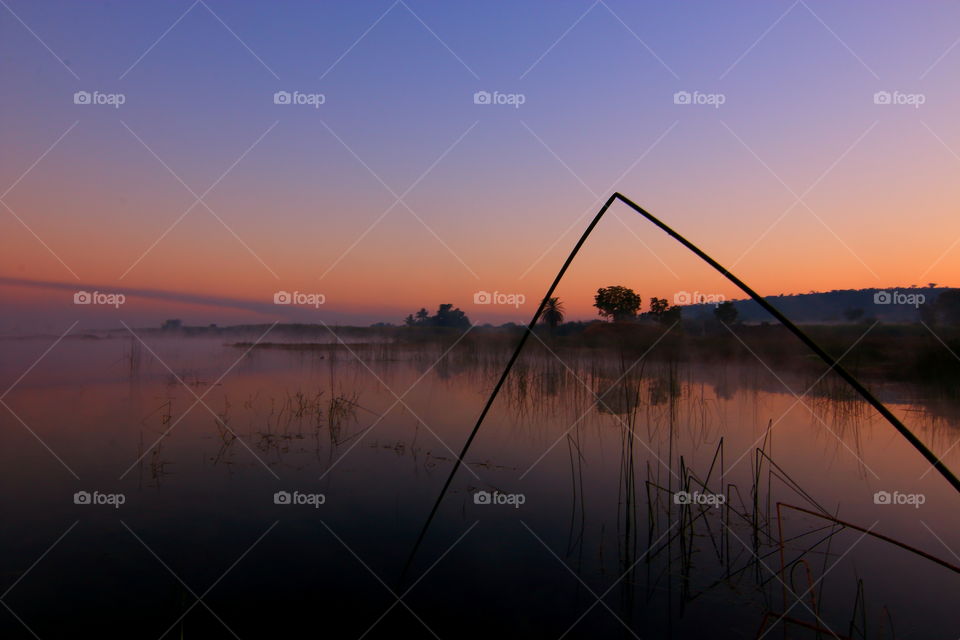 tranquil sunset and reflection on the lake water by the country side