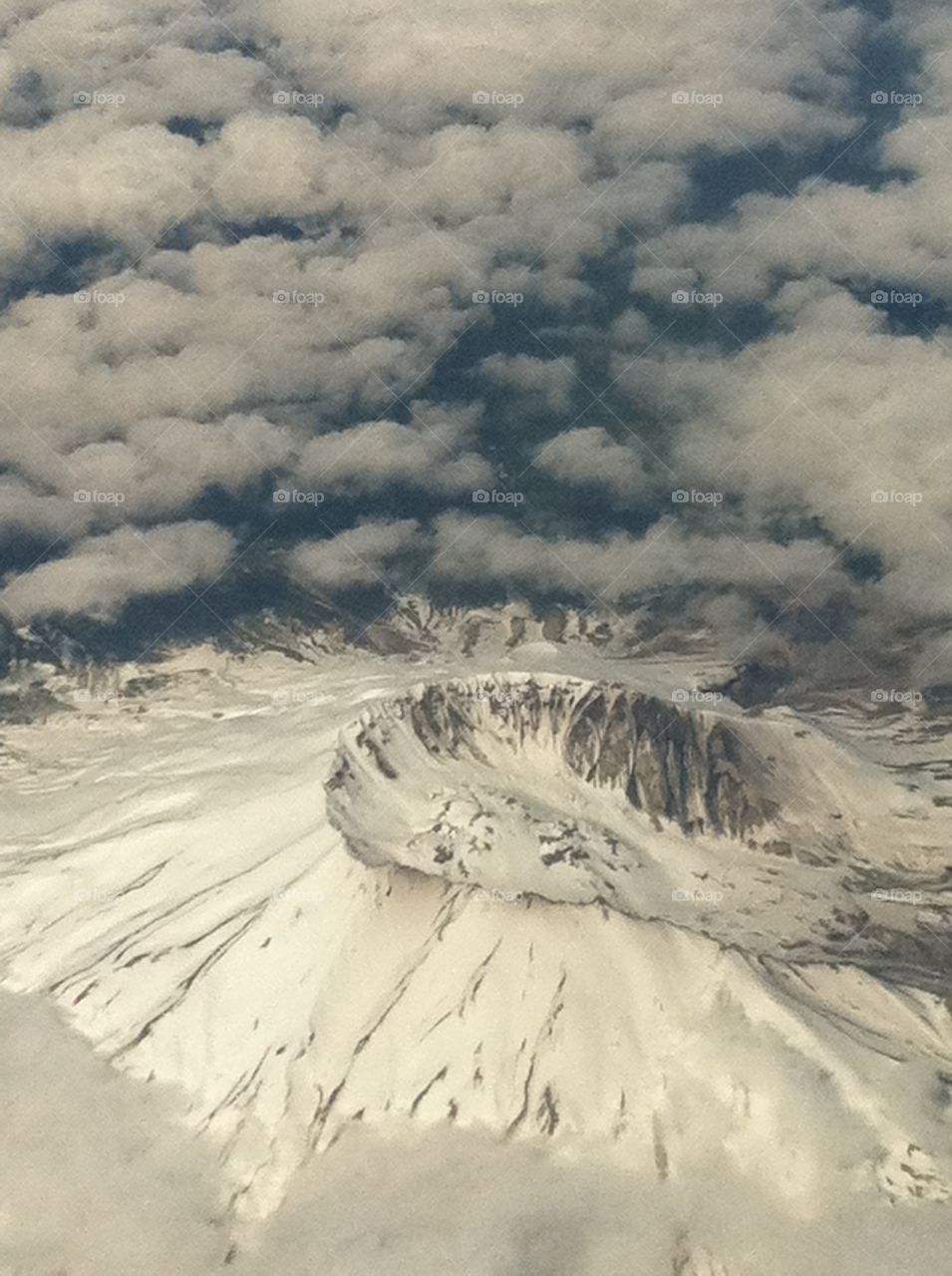 An arial view of Mount Saint Helens's dormant volcanic, snow covered crater. The view looking out from my window seat while on a flight to Vegas