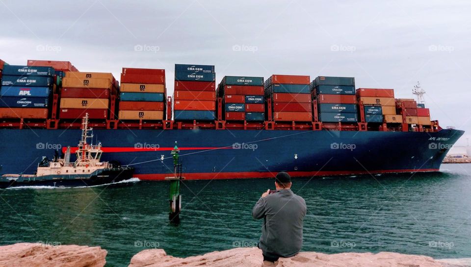 Container ship escorted into harbour.
