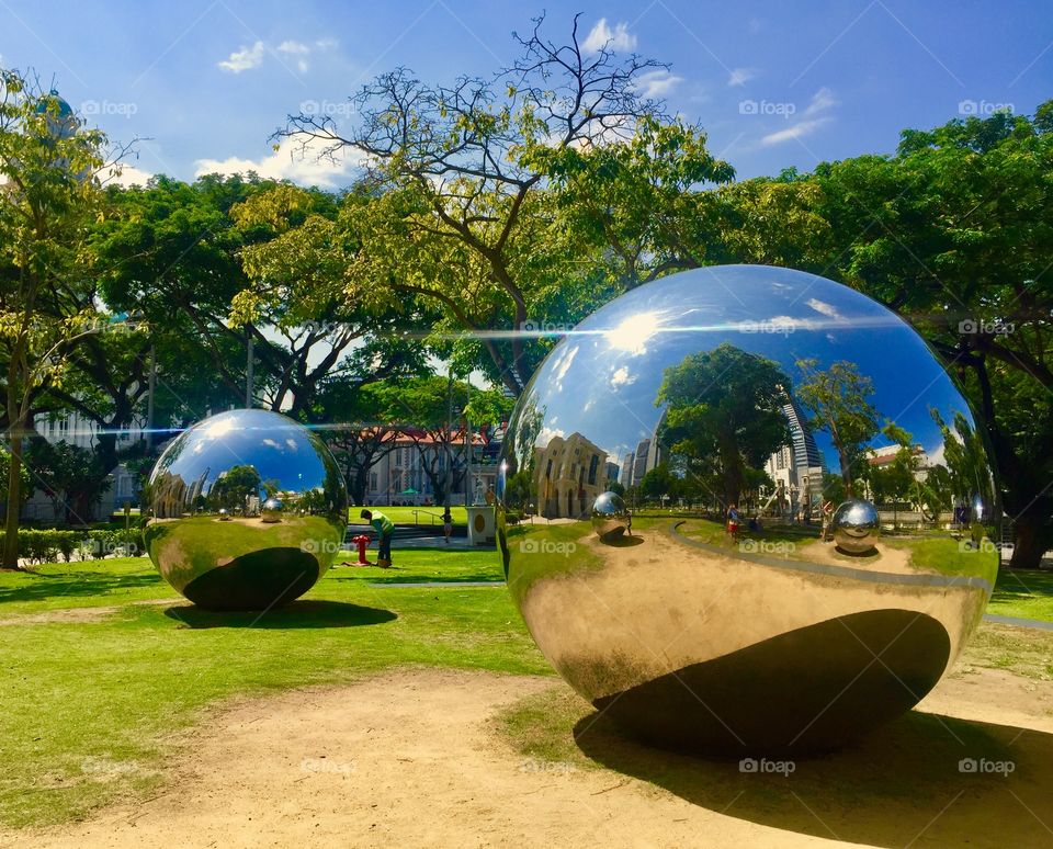 Metal circular architecture surrounded by green trees like nature’s pinball machine