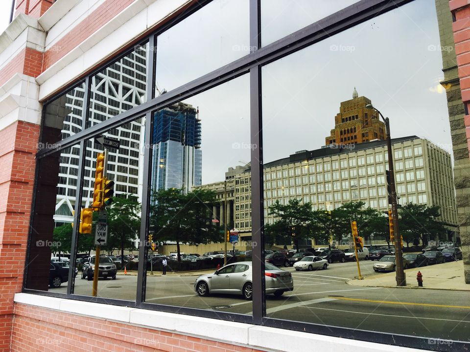 Reflection of cars and buildings on glass window