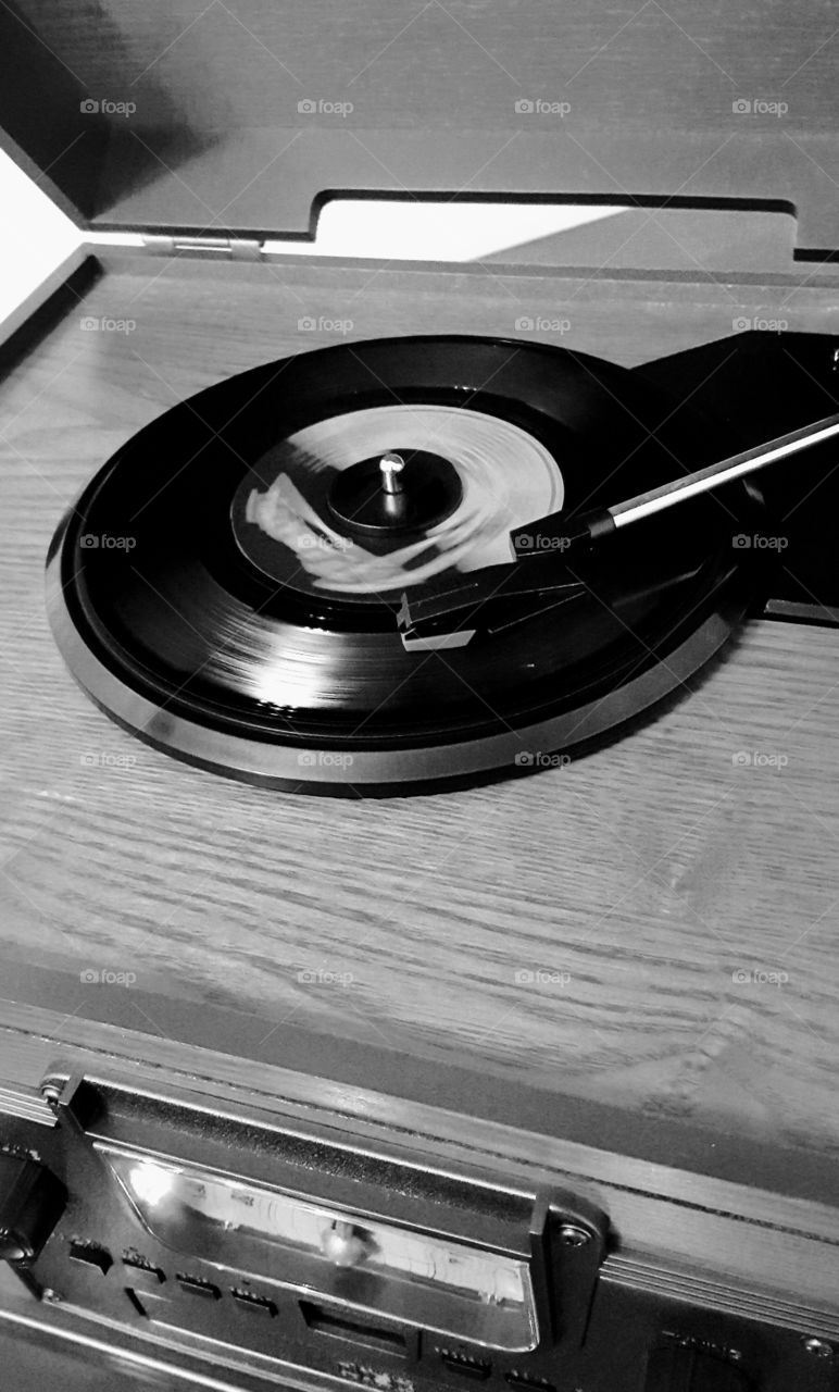 A vinyl record spinning on an old wooden record player.