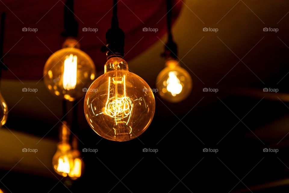 Glowing tungsten light bulbs on black background