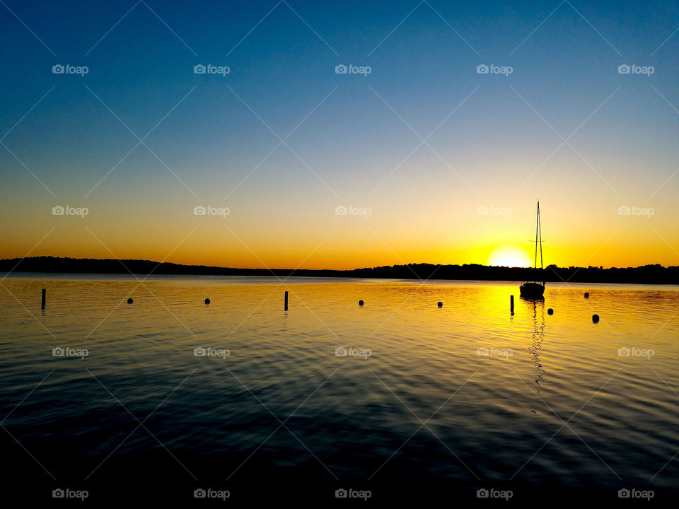 Sailboat on idyllic lake during sunset
