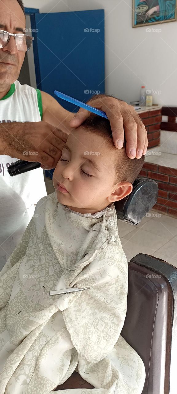 Boy falls asleep while cutting his hair