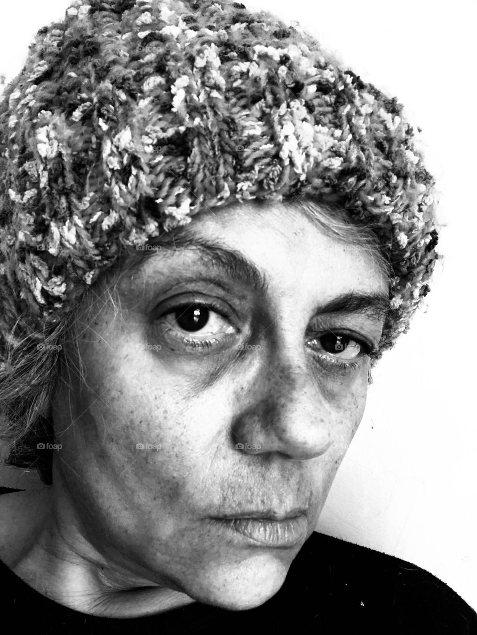 Woman in a wool hat shows her emotions for being stuck indoors during a particular cold winter weekend.