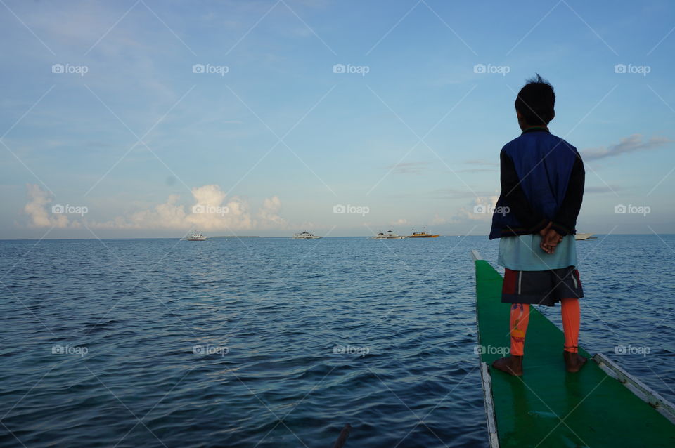 On our way to the mainland, we met this young little boatman.