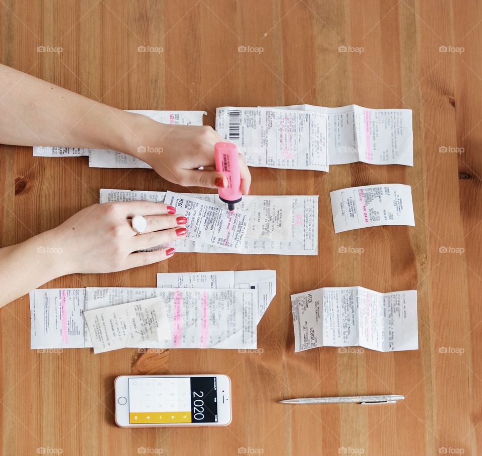 Woman (hands) calculate costs in cash receipts 