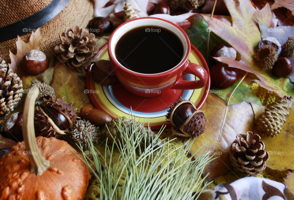 Red cup of coffee in the table, autumn still life