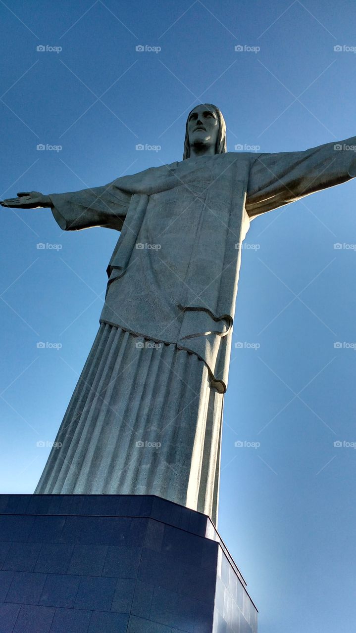 Cristo Redentor Corcovado Rio de Janeiro RJ Brasil

"Christ the Redeemer (Portuguese: Cristo Redentor, standard Brazilian Portuguese: [ˈkɾistu ʁedẽˈtoʁ], local dialect: [ˈkɾiɕtŭ̻ xe̞dẽ̞ˈtoɦ]) is an Art Deco statue of Jesus Christ in Rio de Janeiro, Brazil, created by French sculptor Paul Landowski and built by the Brazilian engineer Heitor da Silva Costa, in collaboration with the French engineer Albert Caquot. Romanian sculptor Gheorghe Leonida fashioned the face. The statue is 30 metres (98 ft) tall, not including its 8-metre (26 ft) pedestal, and its arms stretch 28 metres (92 ft) wide.
The statue weighs 635 metric tons (625 long, 700 short tons), and is located at the peak of the 700-metre (2,300 ft) Corcovado mountain in the Tijuca Forest National Park overlooking the city of Rio. A symbol of Christianity across the world, the statue has also become a cultural icon of both Rio de Janeiro and Brazil, and is listed as one of the New Seven Wonders of the World. It is made of reinforced concrete and soapstone, and was constructed between 1922 and 1931. "
Fonte: Wikipédia, acesso em 06/11/2016.