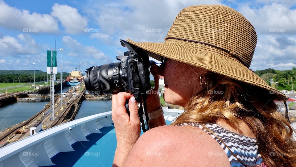Woman photographer taking pictures of the Panama Canal. 