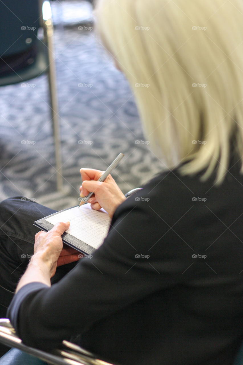 A woman takes notes in a college class