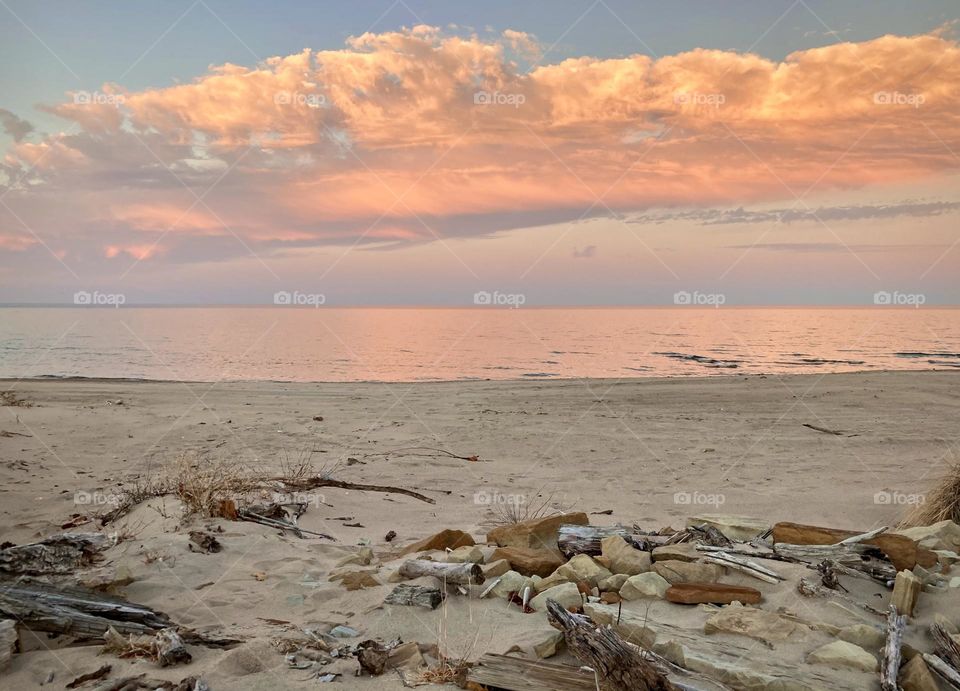 Pink and purple sunset on lake eerie shoreline on Cedar Point’s sandy, rocky beach 
