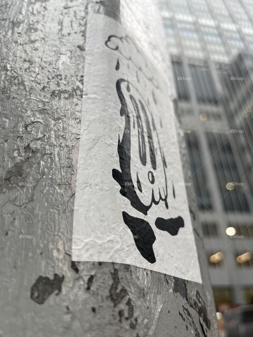 Ghost sticker on New York City pole gray building background 