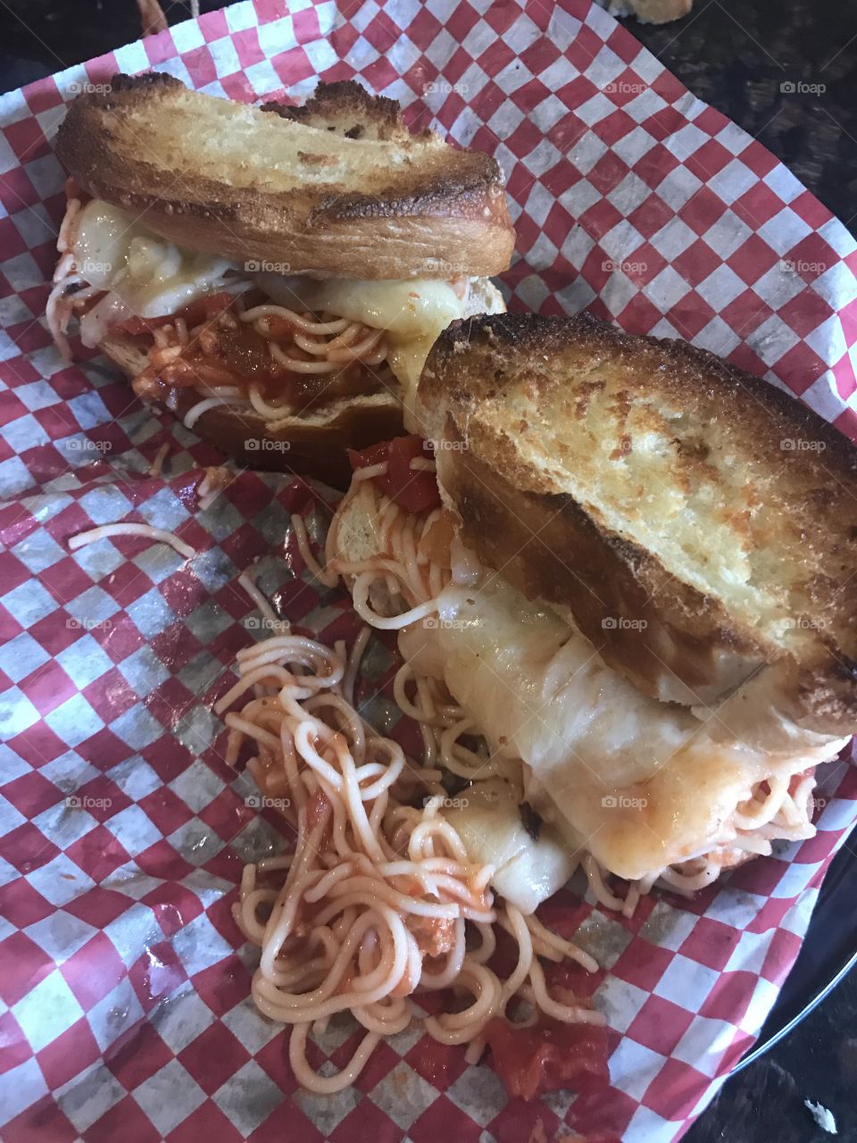Toasted spaghetti and mozzarella cheese sandwich on a checkered background 