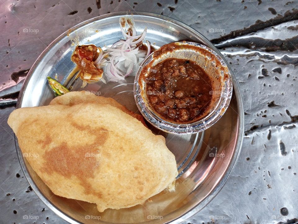 Indian street food Chole Bhature served with onion and pickle