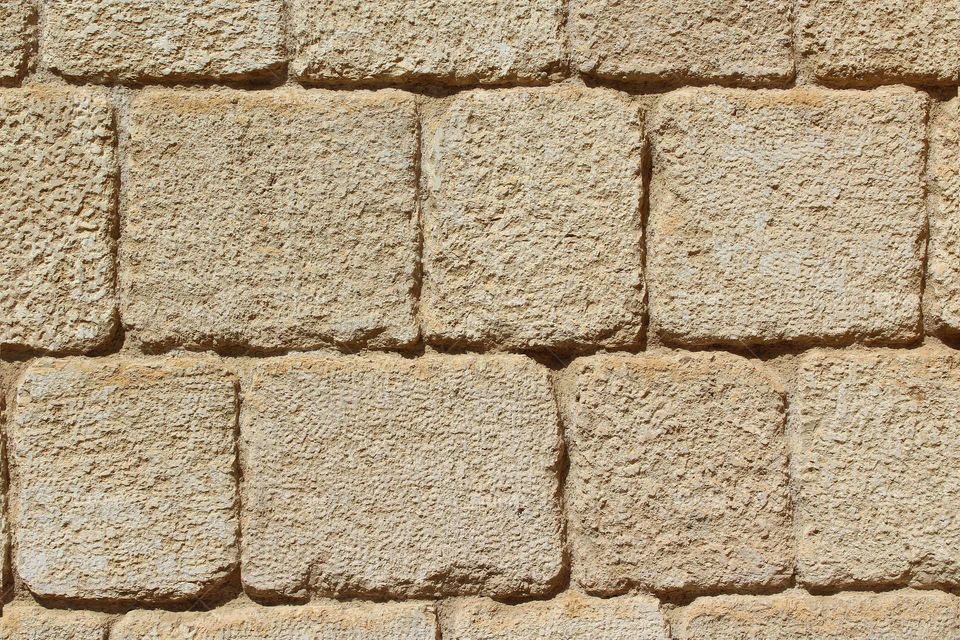 Texture of the stone wall. Yellow stone as modern design of buildings facade