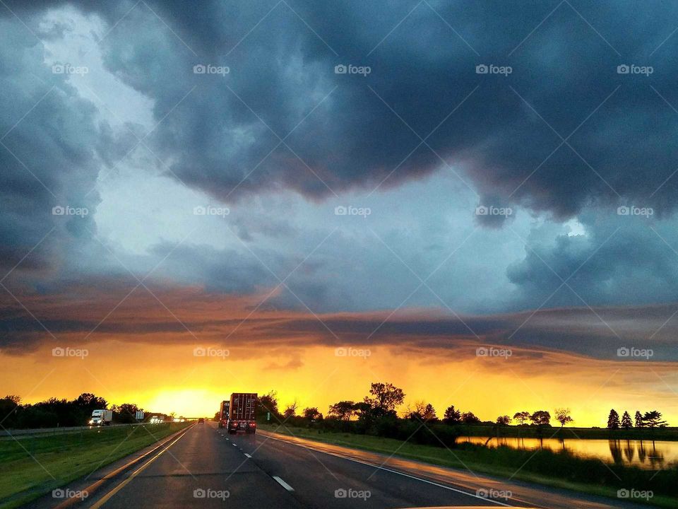 Driving into dramatic sunset after a thunderstorm