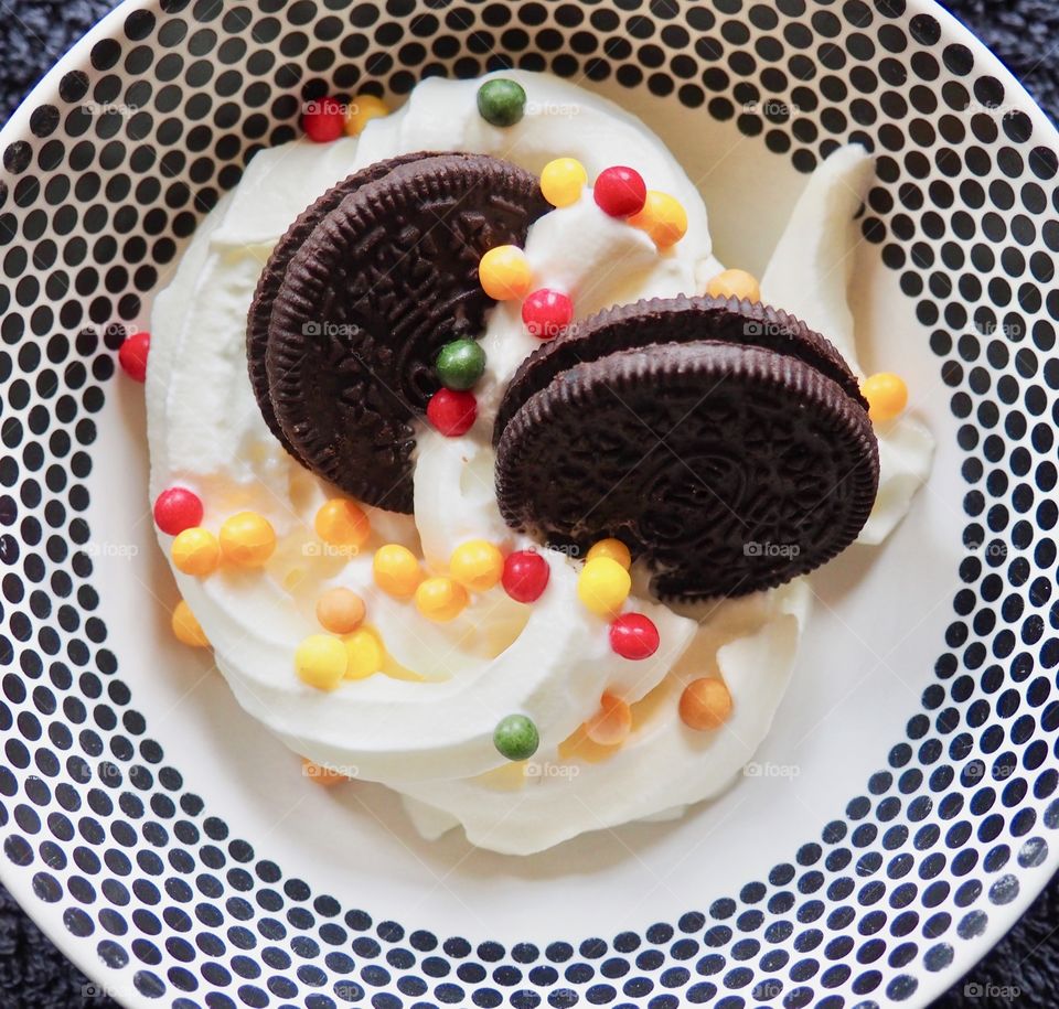 Oreo cookies with whipped cream and sprinkles.