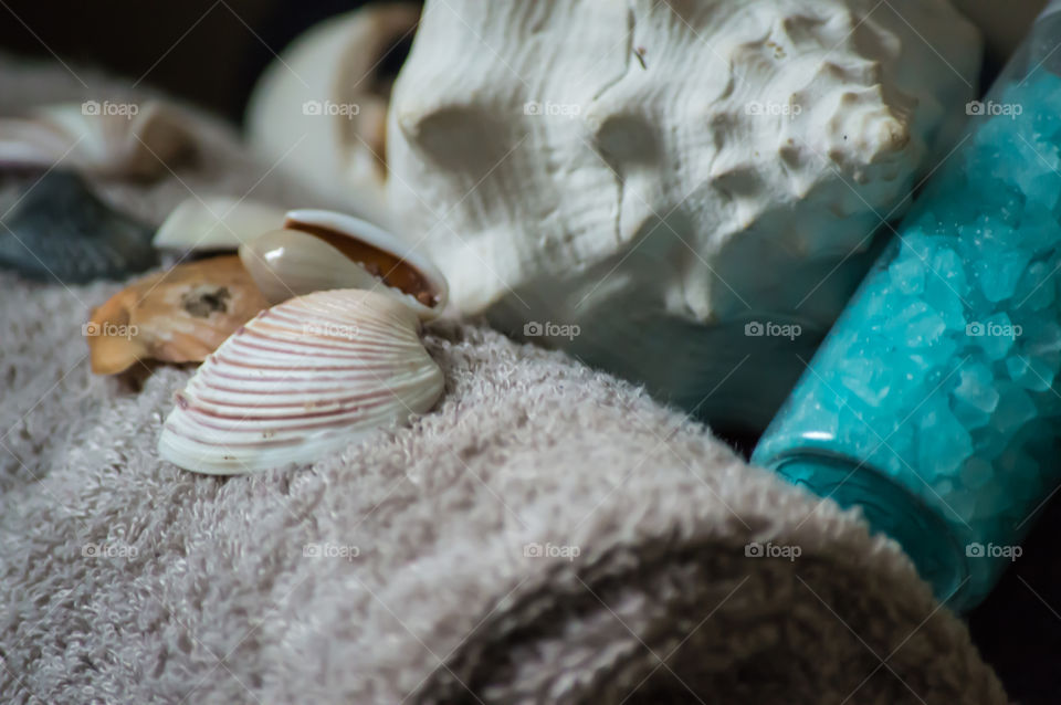 Self care seashells and fresh rolled towels conceptual background with sea salts and white conch full frame photography 