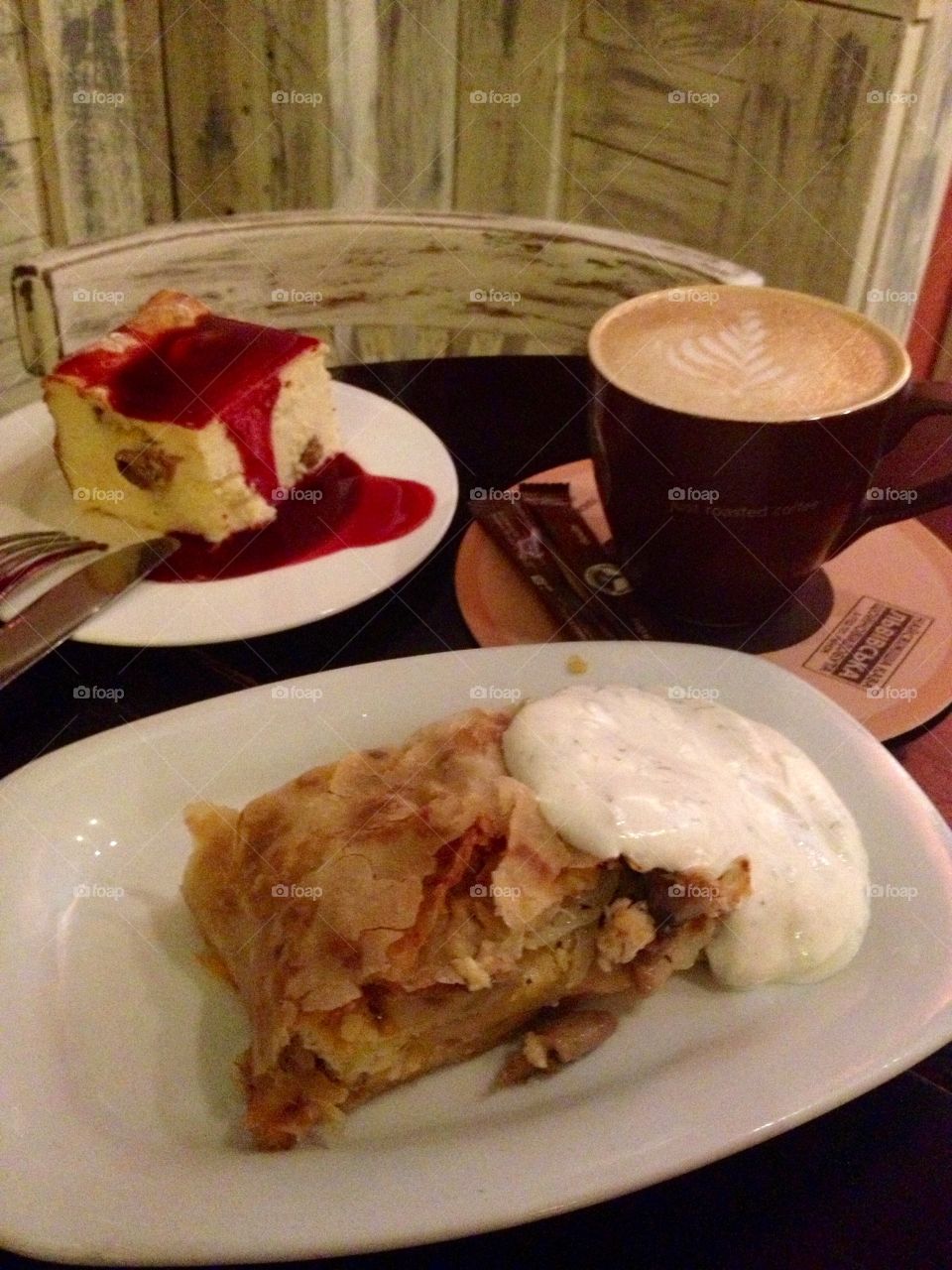 Delicious cakes with sauce and coffee on a wooden table