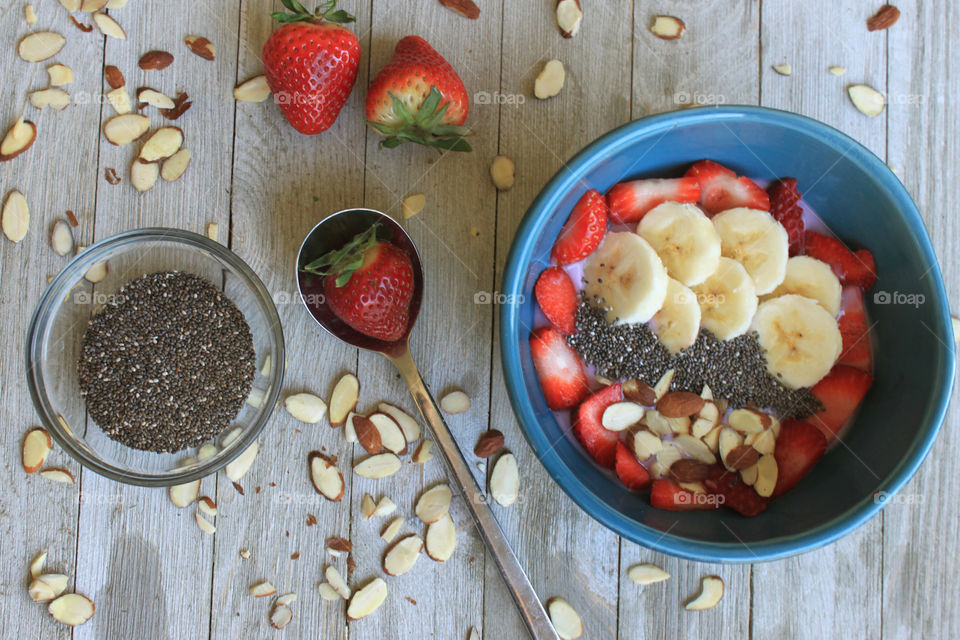 Smoothie with banana, strawberry and almonds in bowl