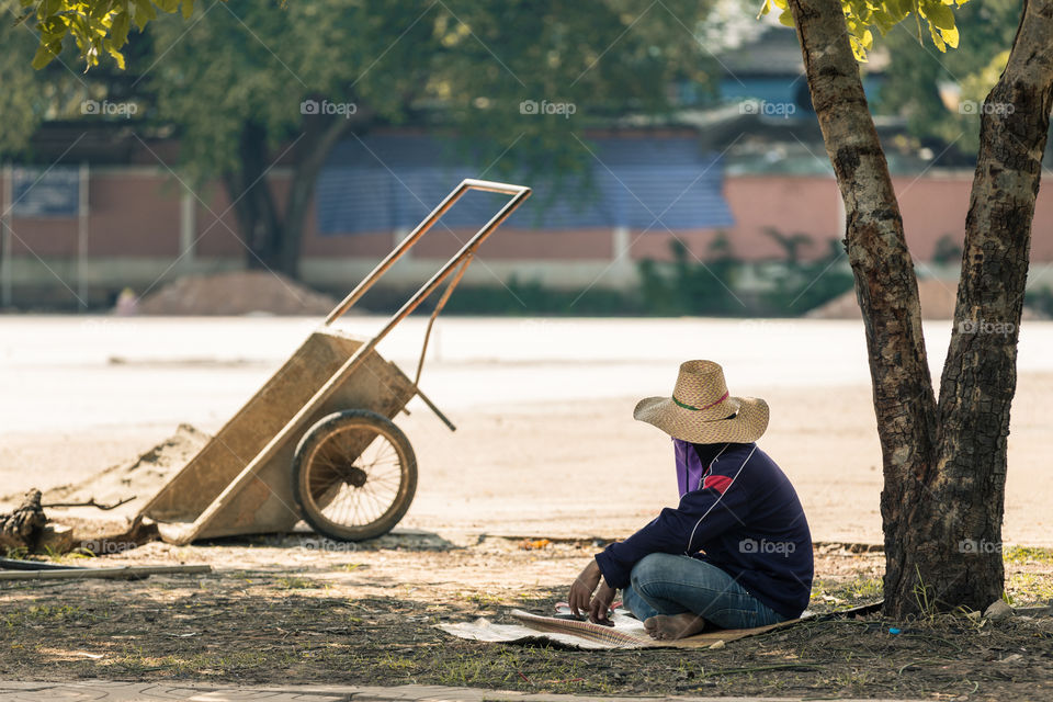 Worker resting under the tree