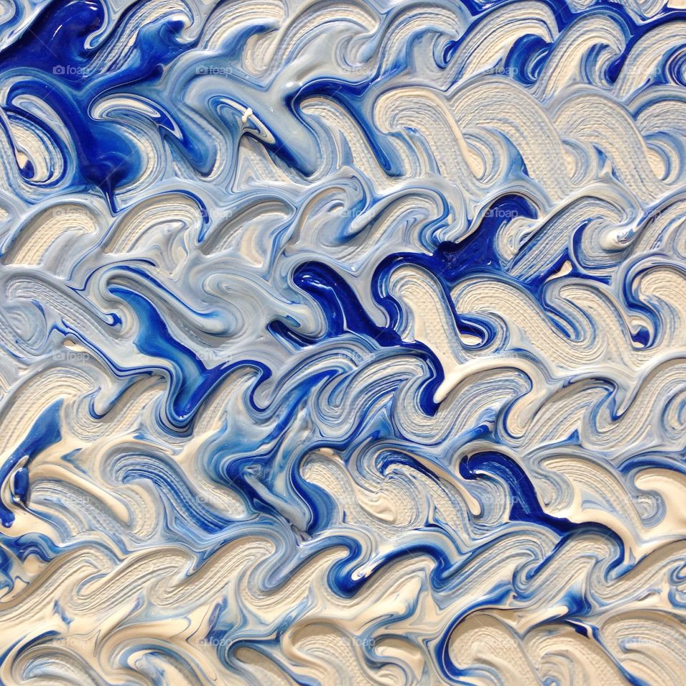 Closeup of thick blue and white paint strokes.