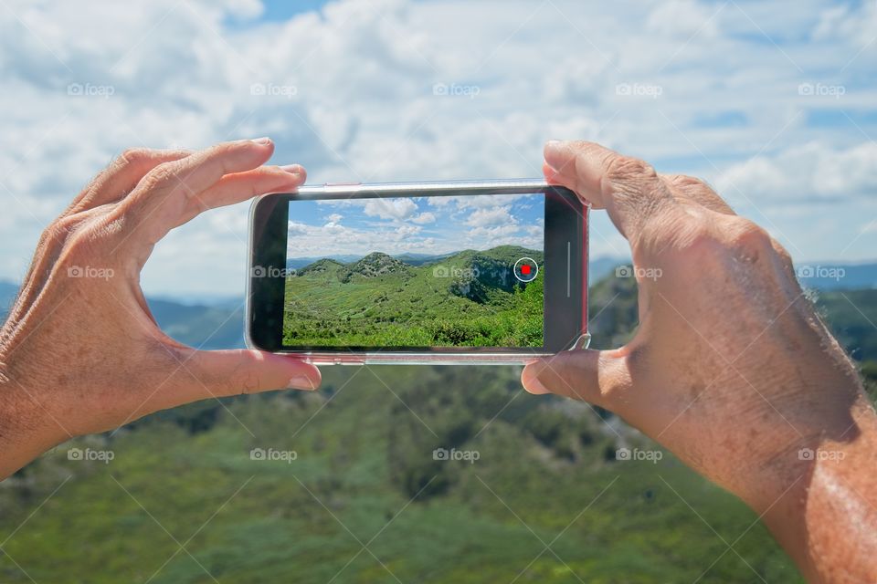 Phone taking a picture of a beautiful landscape