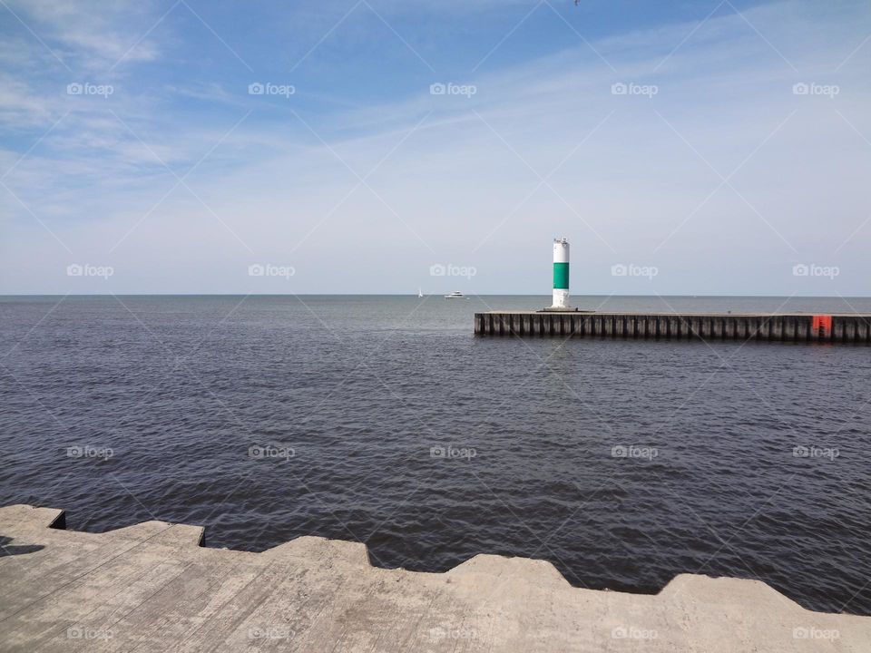 Lighthouse in green and white and the water