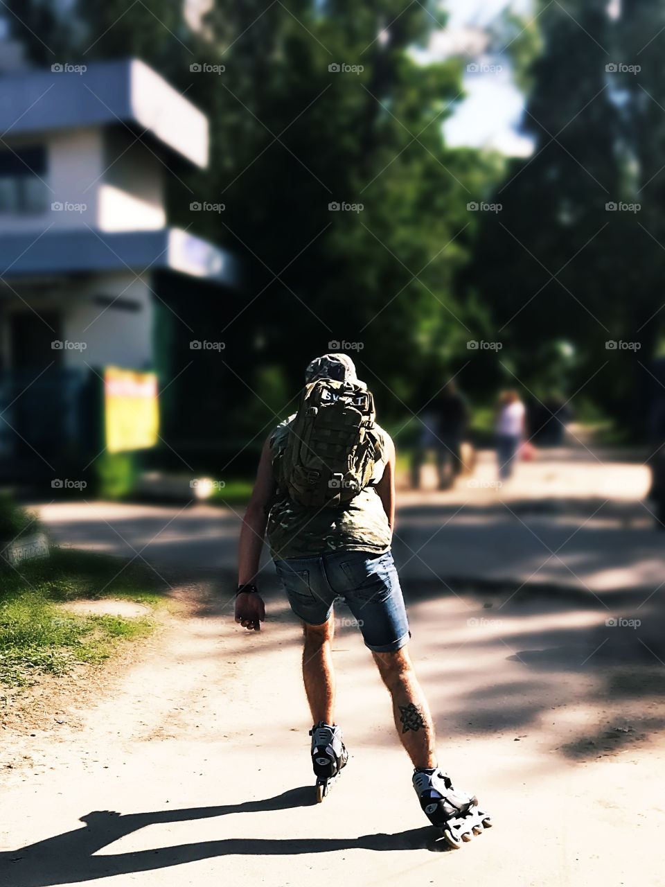 Young man with a backpack roller skating through the city streets 