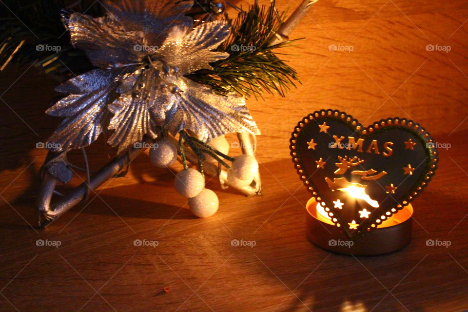 Traditional Christmas decorations, candle light and words on a wooden shelf