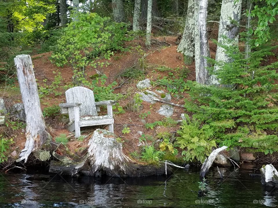 Old wooden chair on edge of lake