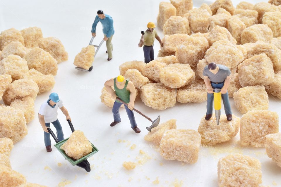 Workers breaking it down sugar cubes 