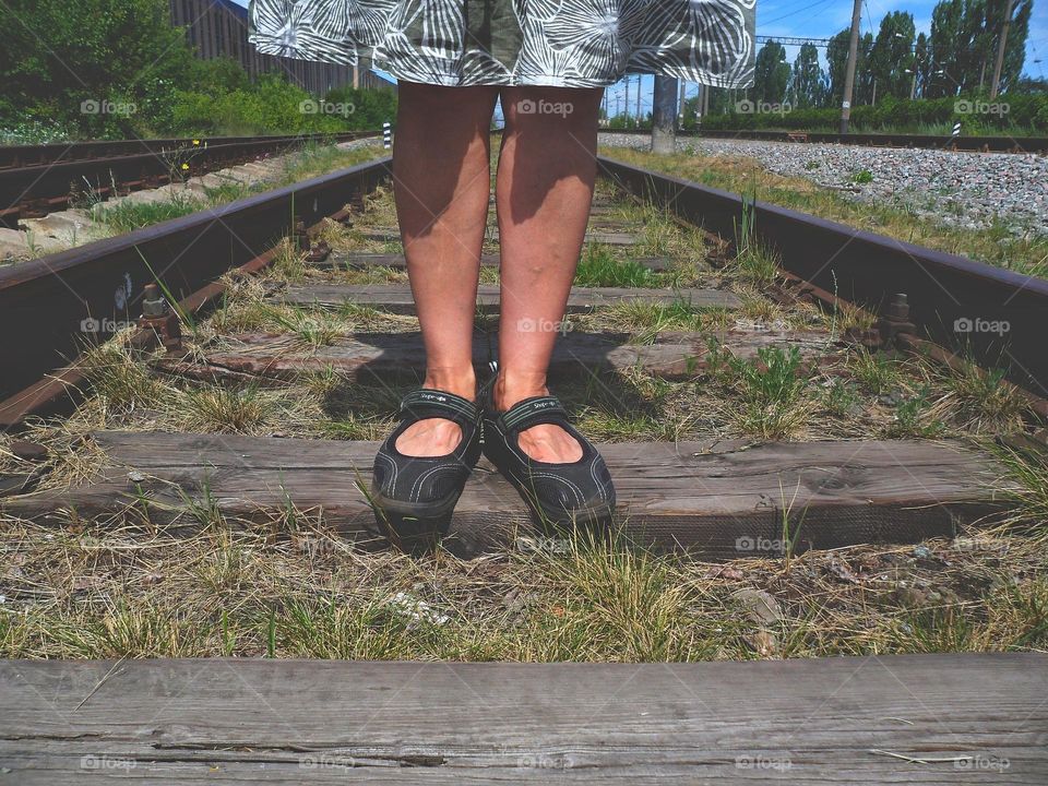 female feet on railway tracks