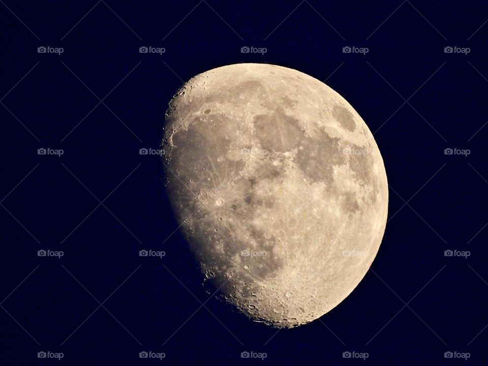 A waxing gibbous moon is in the sky when darkness falls. It lights up the early evening. It appears more than half lighted, but less than full. A waxing gibbous moon comes between first quarter moon and full moon.