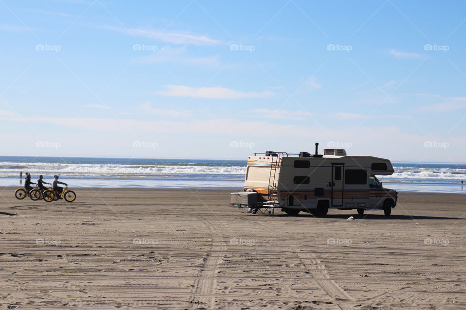 An old RV part at Ocean Shores, bikes riding along the beach.