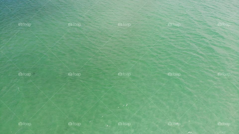 clear water in the ocean. A blue, green, sea surface for background. View From above, flat lay. Aerial view, tropical beach, top view of the waves on the beautiful sand beach. texture of water