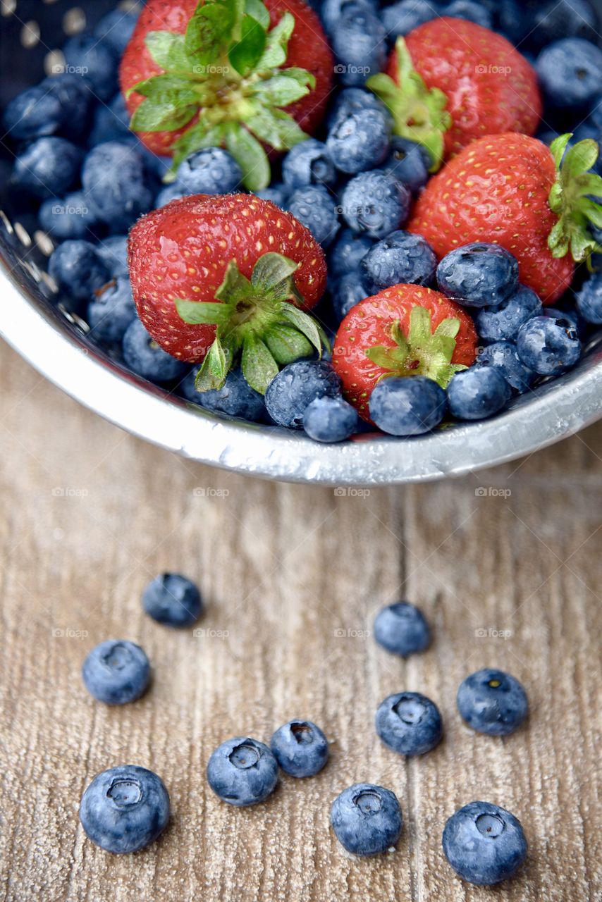 Washing fresh blueberries and strawberries after the market. 