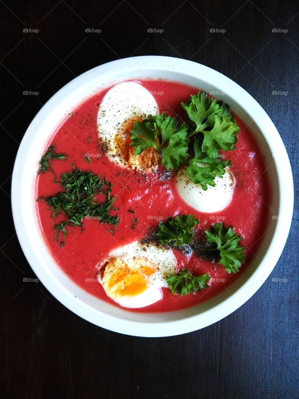 Red beet soup in a white bowl