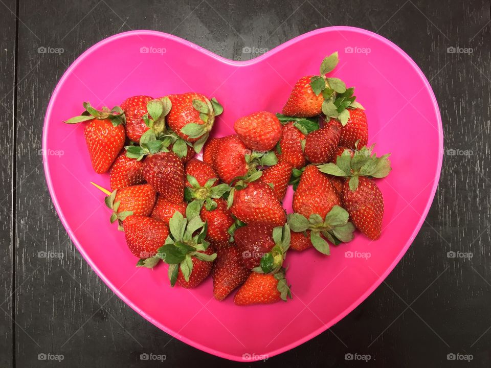 Heart shaped bowl of strawberries.