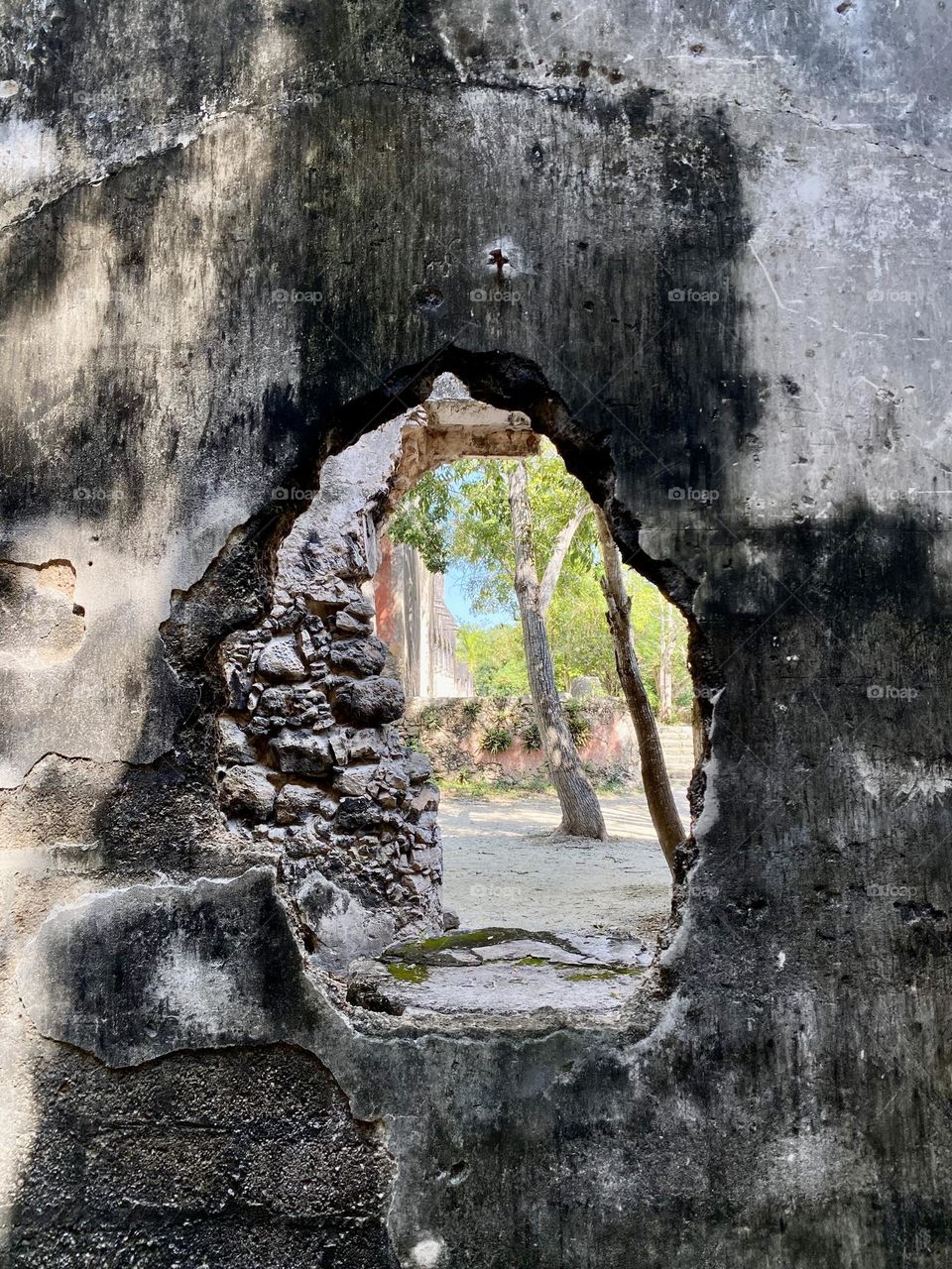 Looking through a hole in the wall of an old Spanish hacienda in Mexico