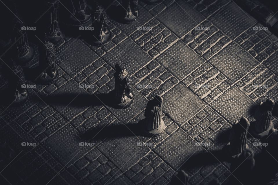 A portrait of two stone soldiers standing in the middle of a chessboard, ready for the strategic duel of the mind.