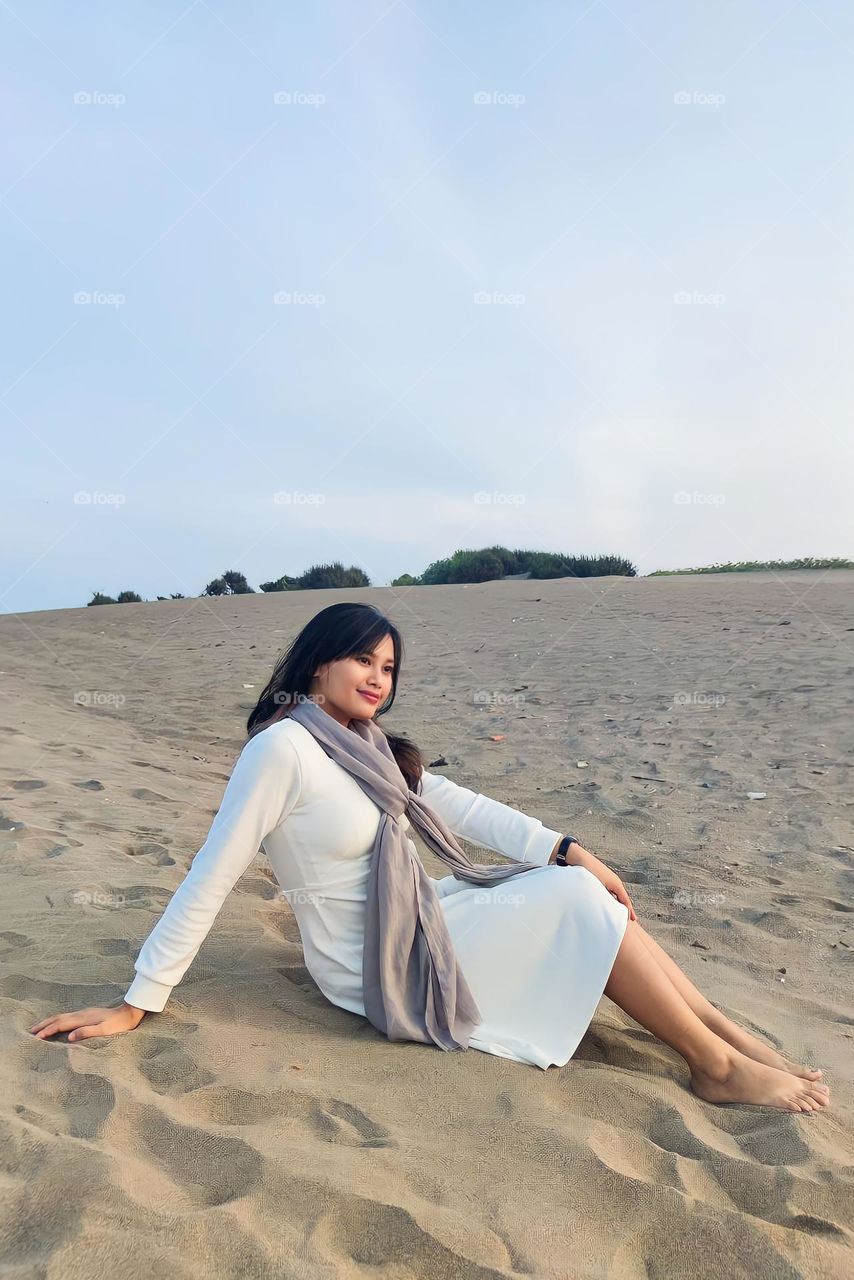 Portrait of a young woman on holiday on a white sand beach on a sunny afternoon