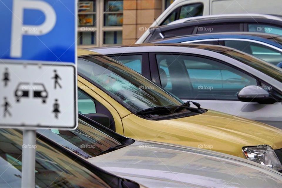 A car sharing traffic sign with parked colorful cars in a row