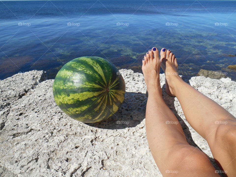 watermelon and female legs resting on a sea summer vacation