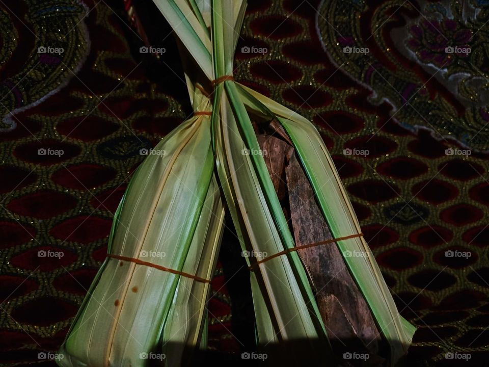 This is palm sugar which is traditionally
made and wrapped in nipa leaves against a red cloth background before being used as a cooking ingredient