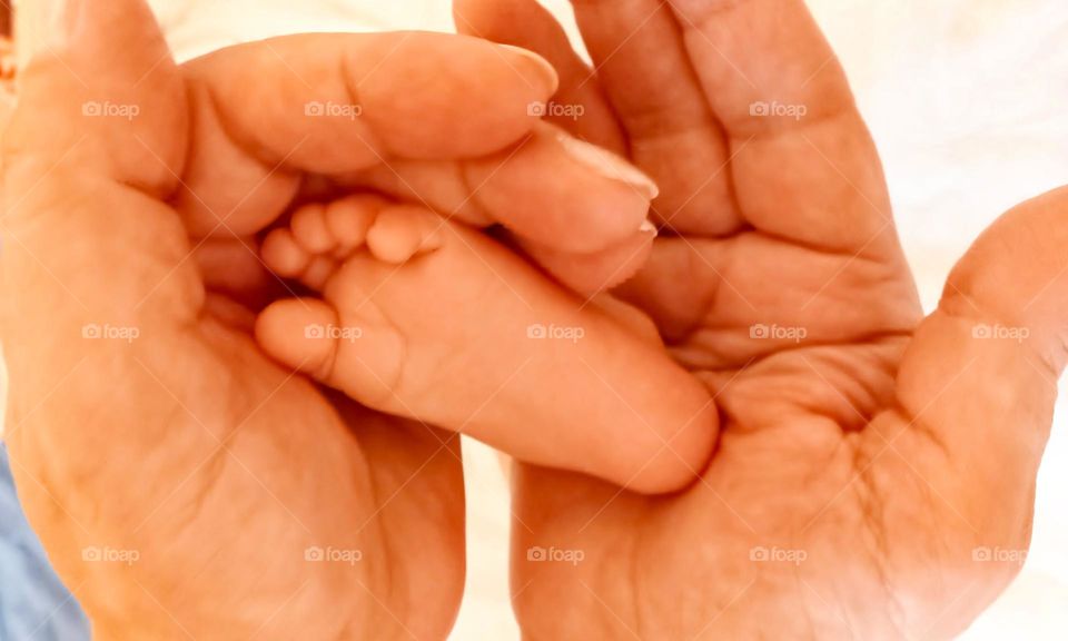 Baby's leg in mother's hands