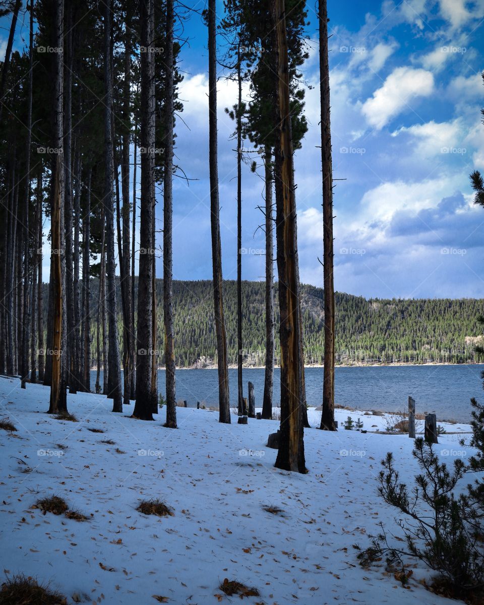 A hike around the edge of the lake surrounded by evergreens and mountains.